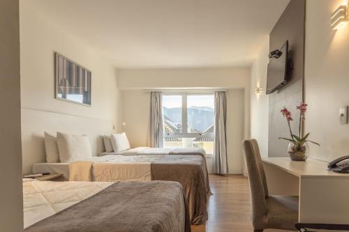 a hotel room with two beds and a window at Americas Townhouse Hotel in Rio de Janeiro