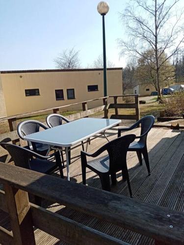 a table and chairs sitting on a deck at Le repaire des renards Vallée de Rabais in Virton
