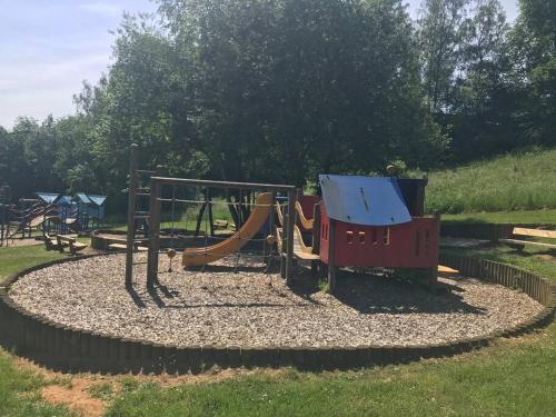 a playground with a slide in a park at Le repaire des renards Vallée de Rabais in Virton