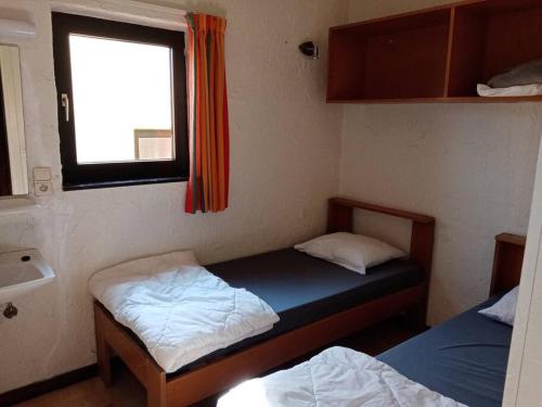 mały pokój z 2 łóżkami i oknem w obiekcie Le repaire des renards Vallée de Rabais w mieście Virton