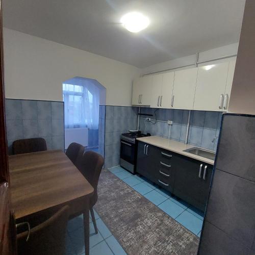 eine Küche mit einem Holztisch und einem Esszimmer in der Unterkunft Apartament Sara in Bîrlad