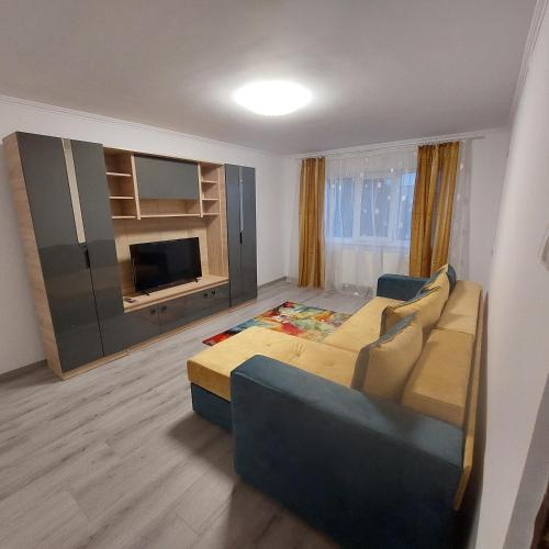 a large living room with a couch and a television at Apartament Sara in Bîrlad