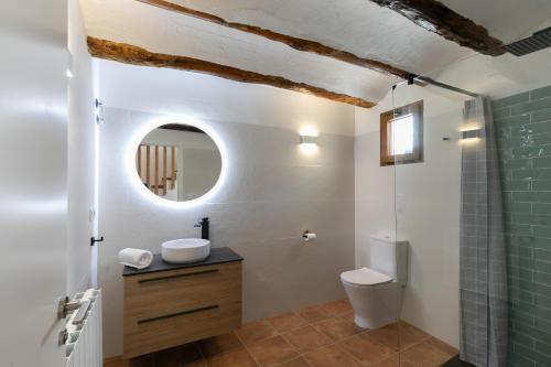 a bathroom with a toilet and a sink and a mirror at Casa Rural Lavadero en Teresa 