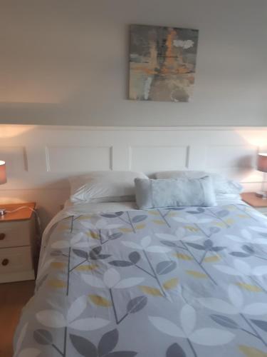a bedroom with a bed with a blue and yellow comforter at Green Acres Guesthouse- Accommodation Only in Killarney