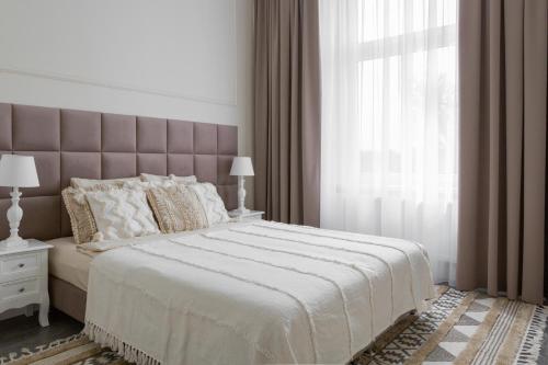 a bedroom with a large bed with a large window at Apartament Veranda in Sopot