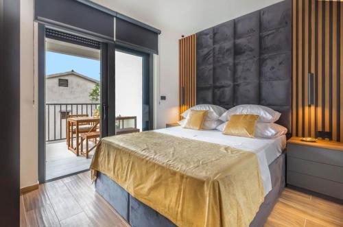 a bedroom with a large bed and a balcony at Luxury Villa Maja in Baška Voda