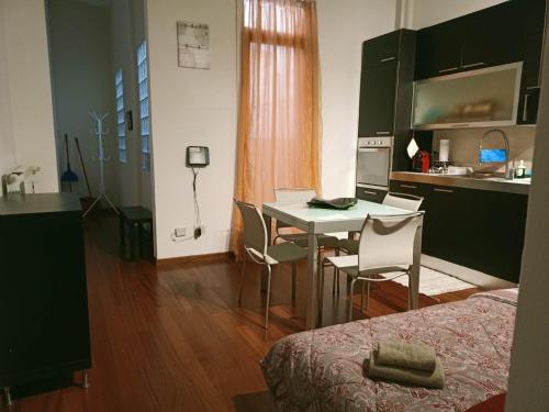 ボローニャにあるMasc 26のテーブルと椅子、キッチンが備わる客室です。