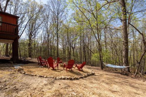 a group of red chairs sitting in a circle in the woods at Relaxing 2-Master Suite Mountain Top - Fire Pit in New Market