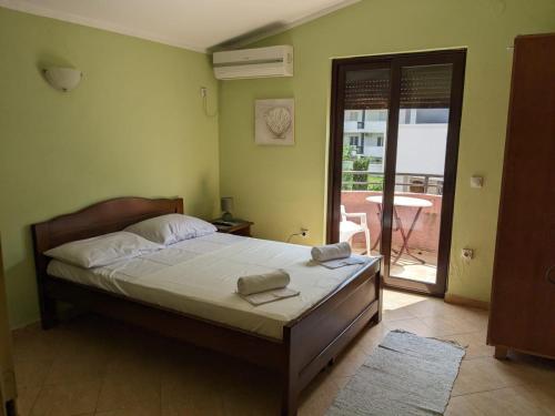 a bedroom with a bed and a door to a patio at Apartments Normannia in Dobra Voda