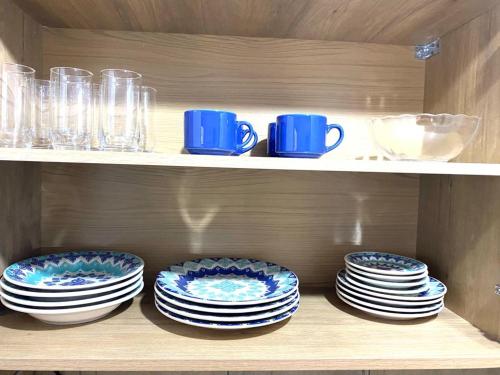 three plates and cups are sitting on a shelf at Sobrado Toledo in São Francisco de Paula