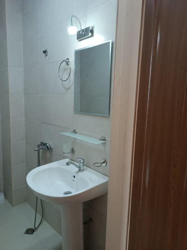 a bathroom with a white sink and a mirror at Lika Hotel in Ureki