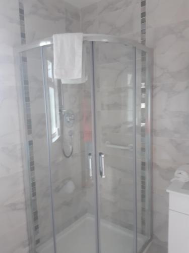 a shower with a glass door in a bathroom at Green Acres Guesthouse- Accommodation Only in Killarney