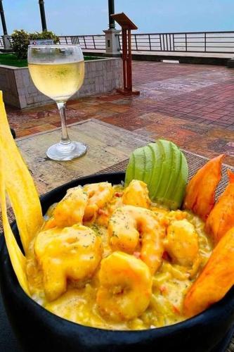 a bowl of food on a table with a glass of wine at EDIFICIO RIVERFRONT II PISO 9 - SUITE 911-2 con ACCESO ÁREA SOCIAL in Guayaquil