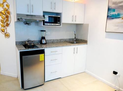 a kitchen with white cabinets and a counter top at EDIFICIO RIVERFRONT II PISO 9 - SUITE 911-2 con ACCESO ÁREA SOCIAL in Guayaquil