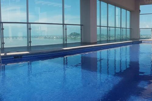 a swimming pool with a view of the water at EDIFICIO RIVERFRONT II PISO 9 - SUITE 911-2 con ACCESO ÁREA SOCIAL in Guayaquil