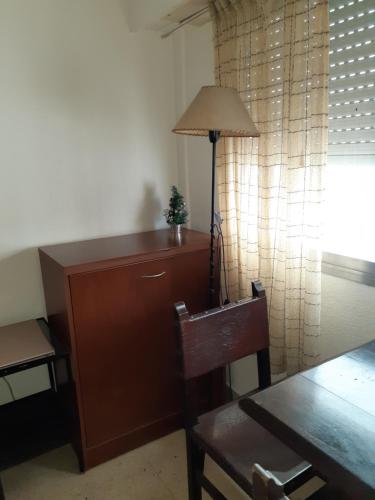 Habitación con escritorio con lámpara y silla. en Monoambiente para tres personas zona centro en Mar del Plata