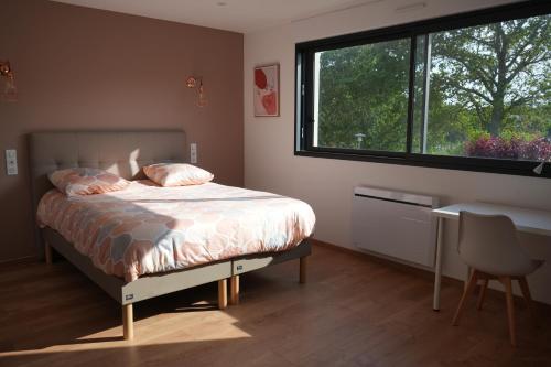 a bedroom with a bed and a window and a desk at Maison contemporaine aux portes de Brest in Bohars