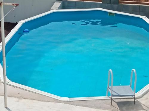 a blue swimming pool with a chair next to it at Azevinho Guest House in Seia