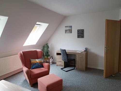 a attic room with a chair and a desk and a window at Ferienwohnung Almdorf in Almdorf