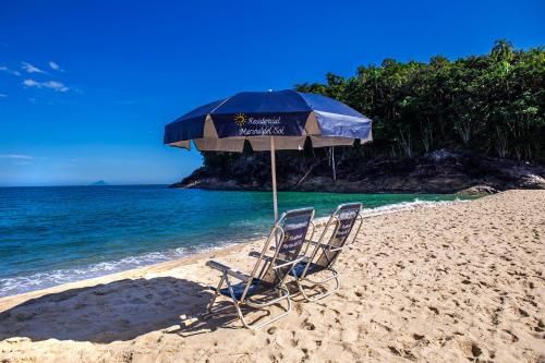two chairs and an umbrella on a beach at Residencial Marina Del Sol in Pauba