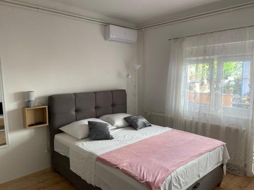 1 dormitorio con 1 cama grande y ventana en Apartmani Gojko, en Biograd na Moru