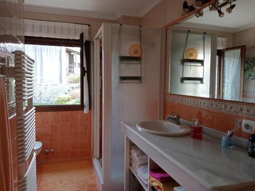 uma casa de banho com um lavatório e um espelho em Marlada Playa de Poo de Llanes em Po