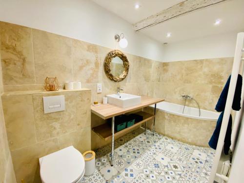 een badkamer met een wastafel, een bad en een toilet bij Le Mas d’Aloha in Plan-dʼOrgon