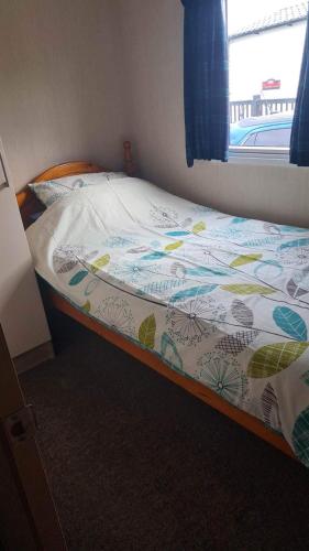 un letto in una camera con copriletto di Grannies Heilan Hame a Dornoch