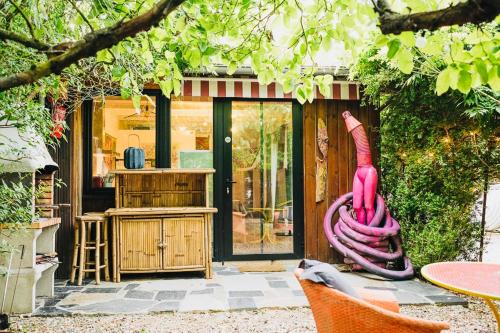 una casa con una manguera rosa delante de ella en Maxia Galega -Arte, Natureza, Relax -Ribeira Sacra, en Monforte de Lemos