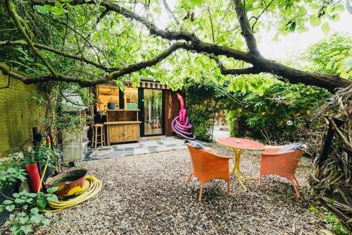un patio con mesa y sillas bajo un árbol en Maxia Galega -Arte, Natureza, Relax -Ribeira Sacra, en Monforte de Lemos