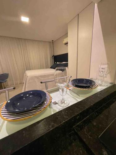 two plates and glasses on a counter in a room at Flat localizado a 200m Shopping Recife, bem Perto da Praia de Boa Viagem e com Wi-Fi 400Mbps in Recife