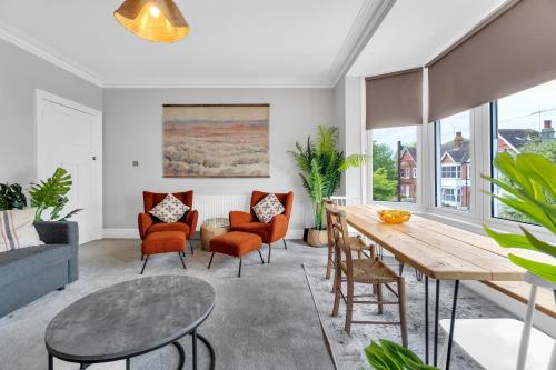 a living room with a table and chairs at Poets Apartment with Free Parking By My Getaways in Worthing