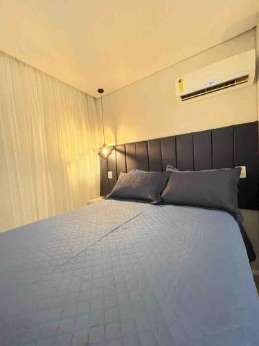 a bedroom with a large bed with gray pillows at Flat localizado a 200m Shopping Recife, bem Perto da Praia de Boa Viagem e com Wi-Fi 400Mbps in Recife