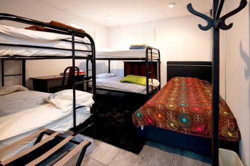 a room with three bunk beds and a table at Auberge Internationale Espace Globetrotter in Rimouski