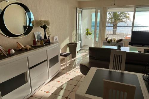 a living room with a large mirror on the wall at Appartement Mar e Souleu avec Terrasse et Vue Mer au Grau du Roi in Le Grau-du-Roi