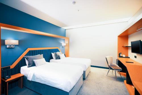 a hotel room with two beds and a blue wall at Roof 264 Hotel & Suites in Sakarya