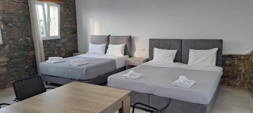 a hotel room with two beds and a table at Fabrica Sunset Apartments in Megali Ammos
