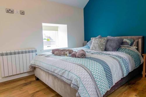 a bedroom with a large bed with a blue wall at Wensleydale Halls in Leyburn