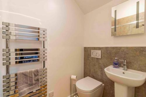 uma casa de banho com um WC branco e um lavatório. em Wensleydale Halls em Leyburn