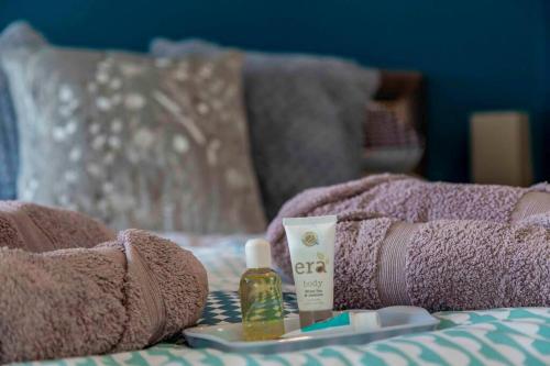a bed with a pink blanket and products on it at Wensleydale Halls in Leyburn