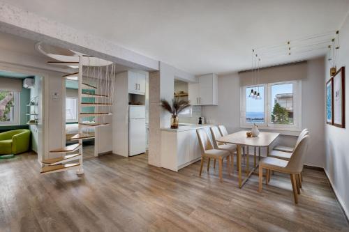 a kitchen and dining room with a table and chairs at Vouliagmeni Stylish Homes by BluPine in Athens