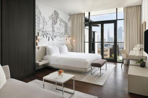 فندق وأجنحة لافيل سيتي ووك دبي، أوتوغراف كولكشن في دبي: غرفة نوم بسرير ابيض وغرفة معيشة