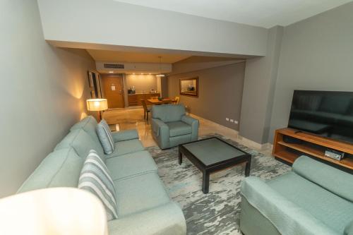 a living room with a couch and a television at Radisson Hotel Santo Domingo in Santo Domingo