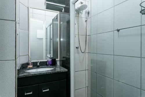 een badkamer met een wastafel en een douche met een spiegel bij Copa Sky Apartments in Rio de Janeiro
