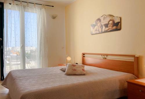 una camera con un grande letto e una finestra di Leuca Villetta Vista Mare a Leuca