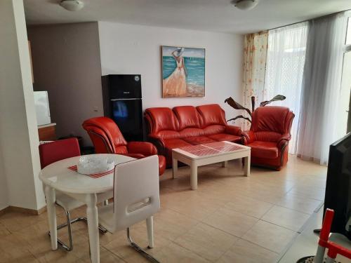 a living room with a red couch and a table at Apartment in Sunny beach, Complex Sun Village, 80 qm, 2 bedrooms & living room near to the beach, SWIMMING POOL, garden in Sunny Beach