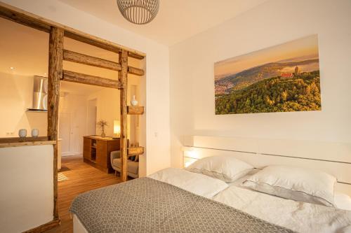 1 dormitorio con 1 cama y una pintura en la pared en Klein aber Fein en Weinheim