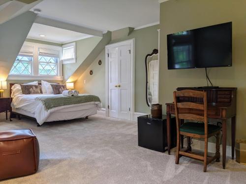 a bedroom with a bed and a television on the wall at Stanton House Inn in Greenwich