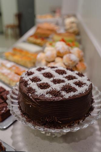 a chocolate cake sitting on a plate on a table at Hotel Caiuá Express Umuarama in Umuarama