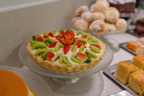 a fruit tart on a glass plate on a table at Hotel Caiuá Express Umuarama in Umuarama